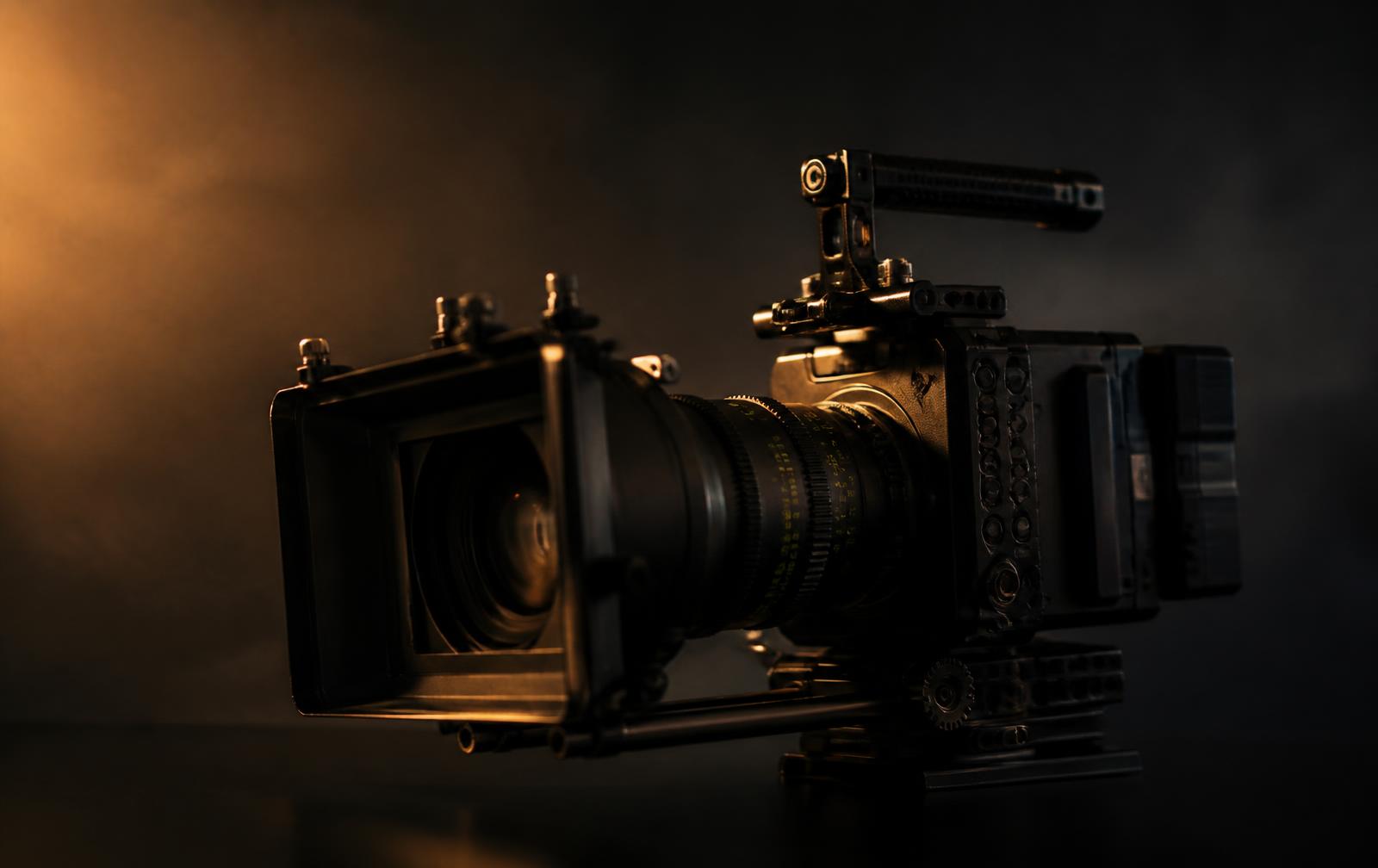 Cinema camera rig with matte box under warm studio lighting